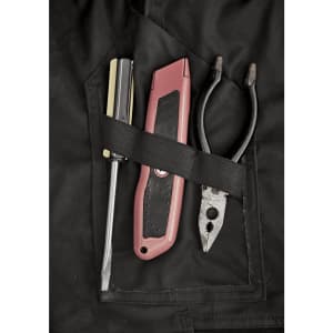 A close-up of a black work pant pocket featuring a screwdriver, utility knife, and pliers secured with a strap.