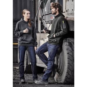 Two individuals wearing black hoodies and blue stretch denim work jeans, standing by a large vehicle.