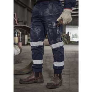 Navy cargo pant with cuffed hems, featuring reflective stripes and multiple pockets, worn with sturdy brown boots.