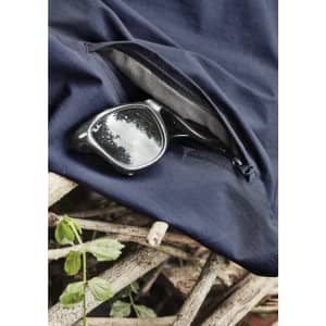 A pair of black sunglasses rests on navy lightweight shorts with a zippered pocket, placed on a textured surface.