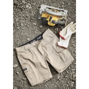 Mens Essential Stretch Cargo Shorts in beige, laid out on gravel, alongside a power tool and gloves. Features branding.