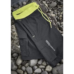 A pair of black sports shorts with a neon yellow waistband and drawstring, featuring a logo.