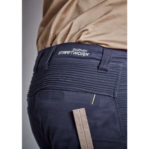 A close-up of navy shorts featuring a branded waistband and a ruler for measuring, highlighting the fabric's texture.