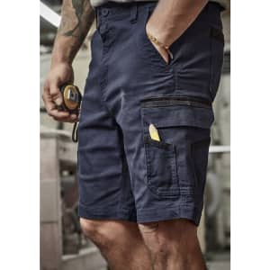 Navy work shorts featuring multiple pockets and a small tool. Close-up of model holding a measuring tape.