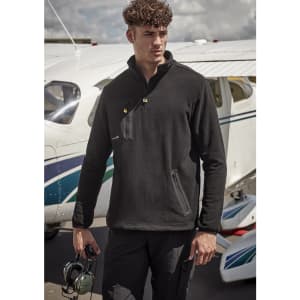 A black lightweight 1/4 zip polar fleece is worn by a model near a small aircraft, featuring a zip pocket and branding.