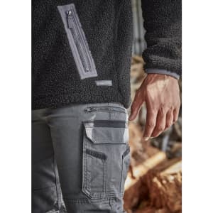 Unisex black Sherpa fleece with zippered pocket, paired with grey work pants featuring cargo pockets and branding.