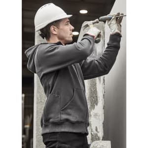 A grey unisex zip front multi-pocket hoodie worn by a worker using a tool, with a safety helmet and gloves.