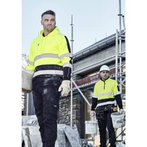 A high-visibility yellow hoodie with black stripes, worn by workers on a construction site, featuring a logo.