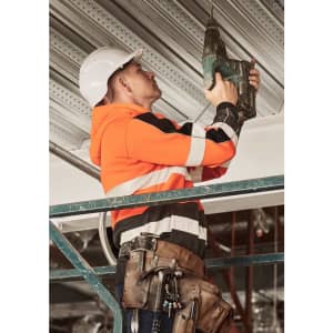 A unisex hi-vis full zip stretch taped hoodie in orange and black, worn by a worker using a drill on a scaffold.