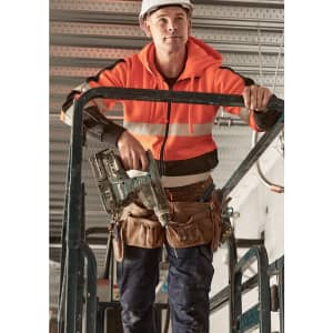 A unisex hi-vis full zip stretch taped hoodie in bright orange, worn by a person holding a power tool while on scaffolding.