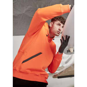An orange unisex water-resistant hoodie featuring a front pocket and a logo, worn by a person working on a surfboard.