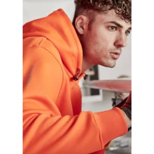 An orange unisex water-resistant hoodie with a logo, featuring a male model.