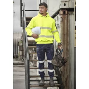A bright yellow water-resistant hoodie with segmented reflective tape, worn with navy work pants and safety gear.