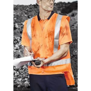 An orange work vest featuring reflective stripes, worn over a navy polo, held by a man writing on a notepad.