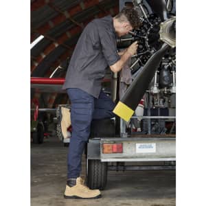 A rugged long sleeve button-up shirt in charcoal grey paired with navy cargo pants and beige work boots.