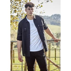A black long sleeve button-up shirt with pockets, modelled by a man outdoors against a natural backdrop.