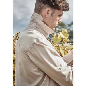 A light beige men's outdoor long sleeve button-up shirt, featuring a collared neck and a logo on the back.