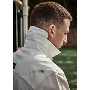 A long sleeve button-up shirt in white, featuring a high collar and casual fit. Includes a logo on the chest.