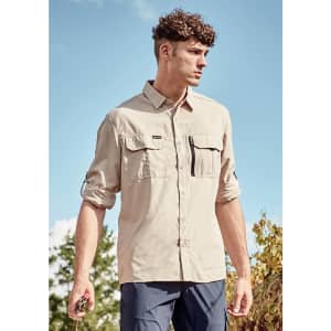 A long-sleeve, button-up shirt in beige, featuring two front pockets and a logo on the chest.