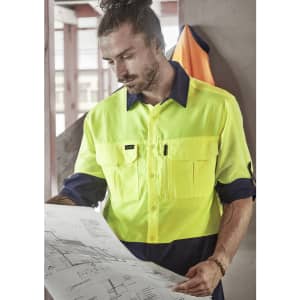 A high-visibility long sleeve shirt in fluorescent yellow and navy, featuring multiple pockets and a logo.