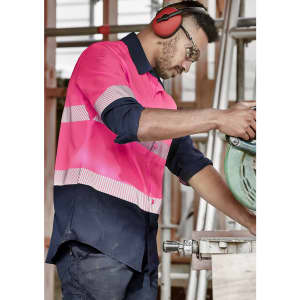 A long sleeve work shirt featuring segmented high visibility pink and navy sections, with a logo displayed on the chest.