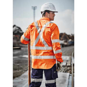 Hi-vis orange long sleeve shirt with reflective tape, worn by a worker on a construction site, featuring a helmet and gloves.