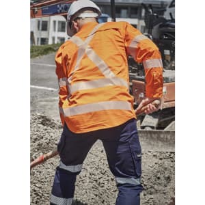A men's hi-vis orange shirt featuring segmented reflective tape, worn with navy blue work pants.