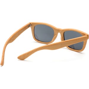 Wood-like sunglasses with grey lenses and light wooden frames, featuring a logo on the side.