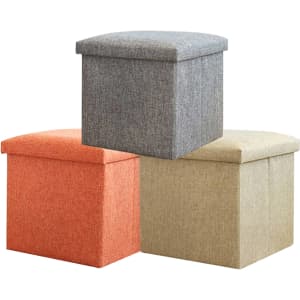 Three foldable storage ottoman boxes in grey, orange, and beige stacked together, featuring a textured fabric finish.