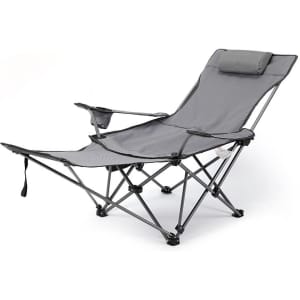A grey camping lounge chair with an adjustable reclining feature and a headrest, featuring a side cup holder and a logo.