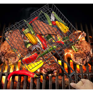 A barbecue net holding grilled vegetables and meats above glowing coals, featuring a black wire design.