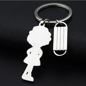 A silver keychain featuring a nurse figure and a mask shape, set against a dark background.