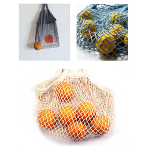 A cotton mesh bag in grey, blue, and cream, filled with oranges. Each bag has a logo.