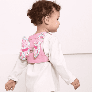 A pink child anti-lost back strap featuring butterfly-shaped straps and floral patterns. It has a logo.