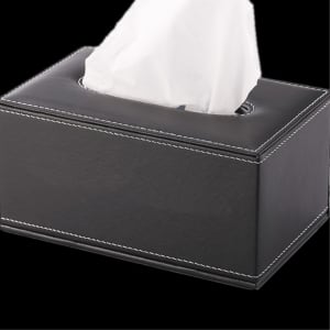 A sleek black leather tissue box with white stitching and a tissue peeking out from the top.