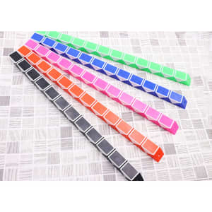 A set of colourful, segmented magic rulers in green, pink, blue, orange, and black, arranged in a line on a patterned surface.