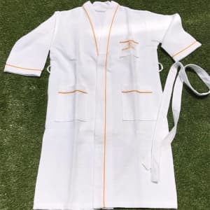 A white cotton unisex bathrobe with orange trim, featuring two front pockets and a tie belt.
