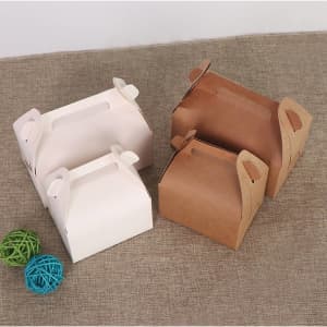Two Gable Boxes in white and brown, featuring handles and positioned on a textured surface, with decorative coloured balls nearby.