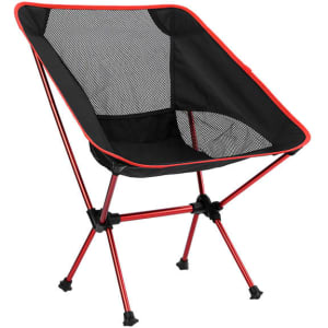 A folding chair in black with red accents, featuring a mesh back and a lightweight frame. Includes a travel bag.