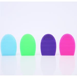 Four silicone makeup brush cleaners in blue, green, purple, and pink, featuring textured surfaces for cleaning.