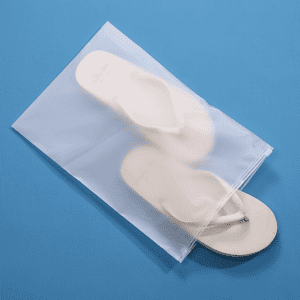 A frosted, waterproof zip-lock storage bag contains white flip-flops, set against a blue background.