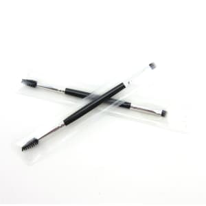 A double-headed eyebrow brush with a black handle and clear packaging, featuring a spoolie and angled brush.