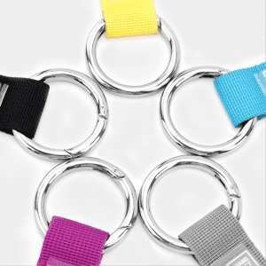 A selection of luggage belts in black, yellow, purple, blue, and grey with shiny metal rings.