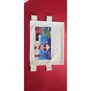 A white fabric advertising cover featuring a tropical beach scene, sunglasses, and branding logos.