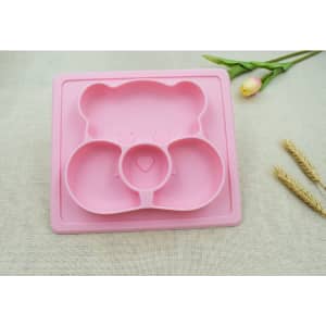A pink non-slip children's plate featuring a bear design with three compartments, accompanied by a flower and decorative elements.