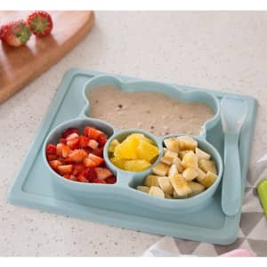 A non-slip children's plate in soft blue, featuring divided sections for food and a matching spoon.