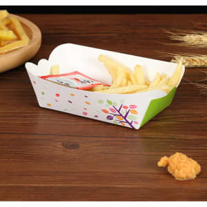 A food tray in green and white, featuring colourful dots and a floral design, filled with fries and a sauce packet.