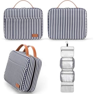 A navy and white striped hanging travel toiletry bag with a leather handle and transparent compartments inside.