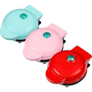 A heart-shaped baking waffle maker in mint green, pink, and red colours, features a button and a logo.