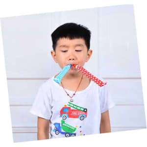 A child holds two colourful party whistles, one blue with polka dots and one red with polka dots, in their mouth.